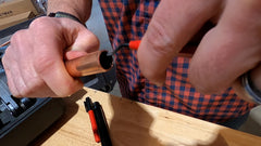 close up of hands cleaning copper pipe with hand reamer