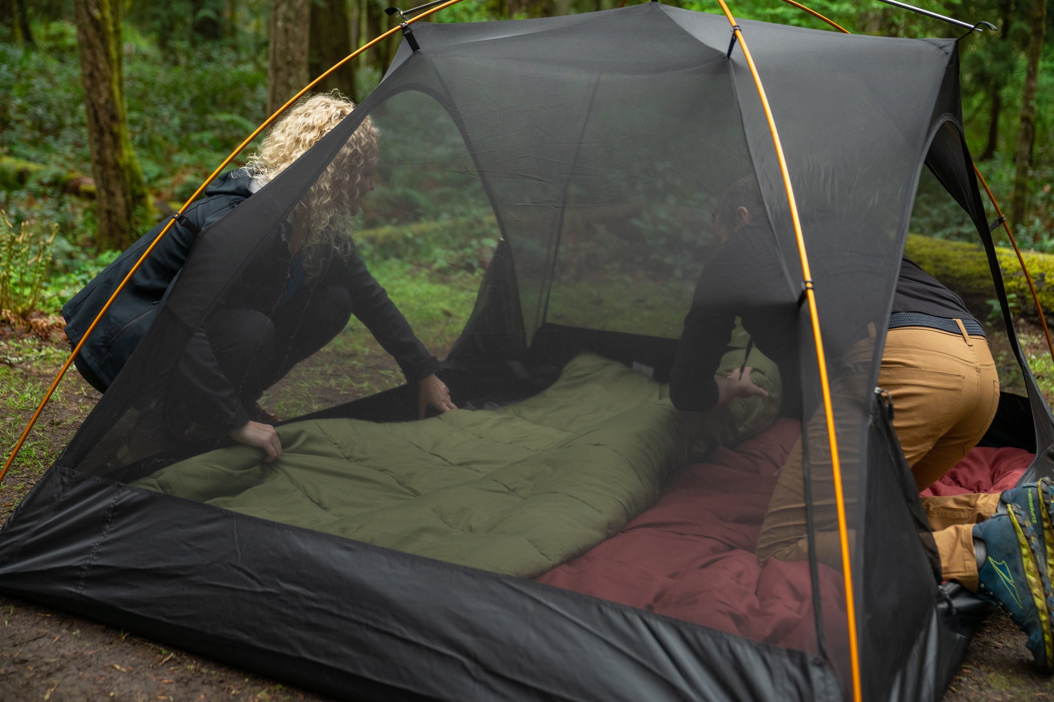 A TETON Sports Mountain Ultra Tent without the rainfly showing its mesh tent top with two people inside.