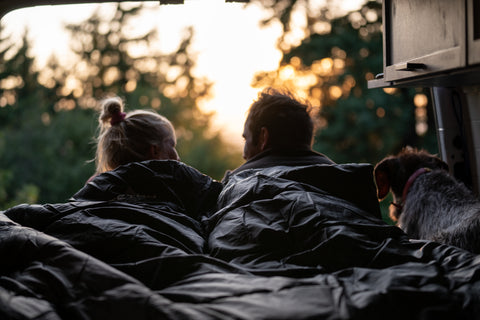 A couple faces away from the camera while snuggled together in a TETON Sports mammoth sleeping bag.