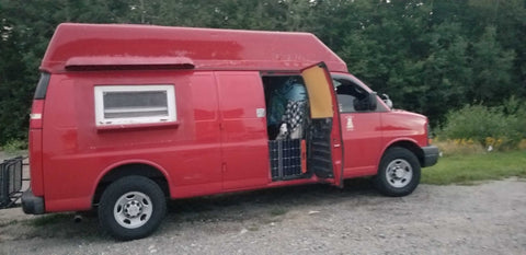 A red cargo van has been converted for a van life adventure.