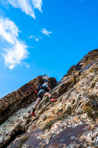 A climber ascending the side of a mountain.