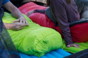 Two people in TETON Sports LEEF Mummy Sleeping Bags talking together.