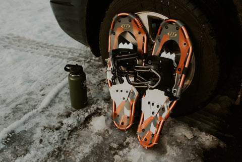 Snowshoes leaning against a vehicle.