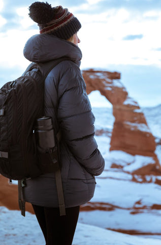 A single female hiker wears a TETON Sports backpack in Arches National Park.