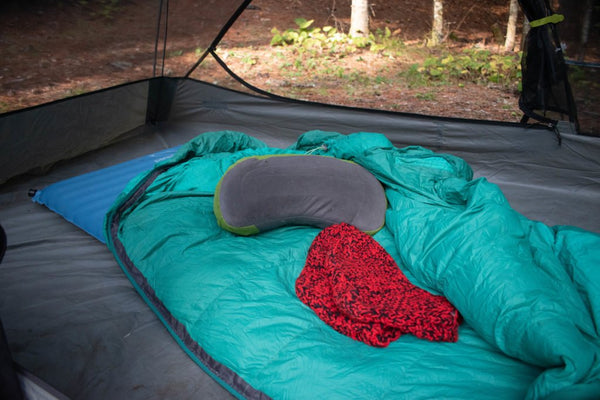 A teal TETON Sports double wide sleeping bag is open on the floor of a tent.