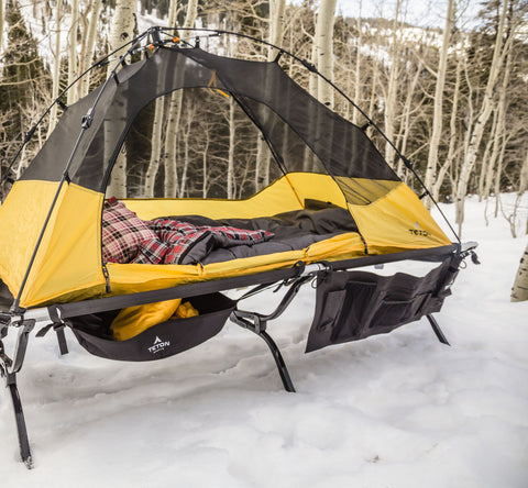 Hands roll up a TETON Sports canvas camp pad.