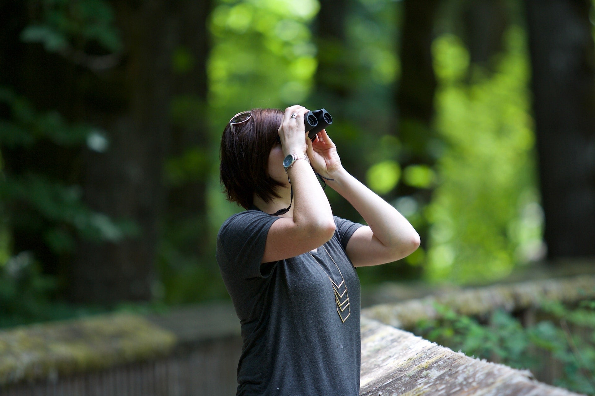 A woman uses binoculars.