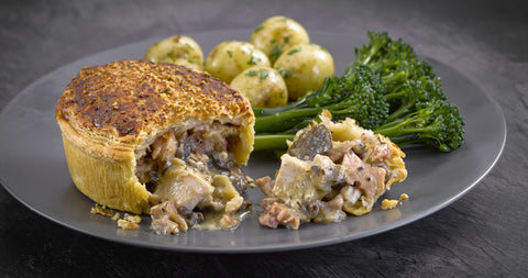 Image of a chicken, bacon and mushroom pie, plated with tenderstem broccoli and new potatoes