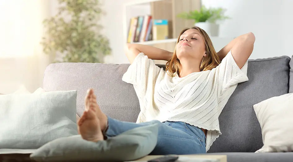 Frau liegt entspannt auf dem Sofa