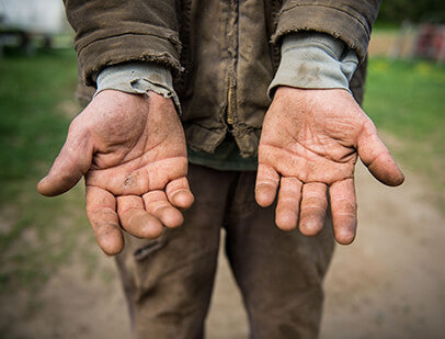 Farmer holding palms of hands out