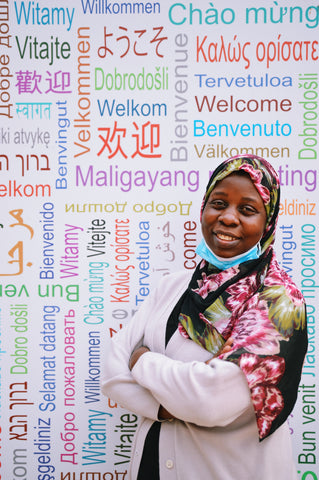 Person standing in front of a wall with the word welcome translated into many languages