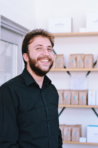 Person in front of coffee bags on a shelf