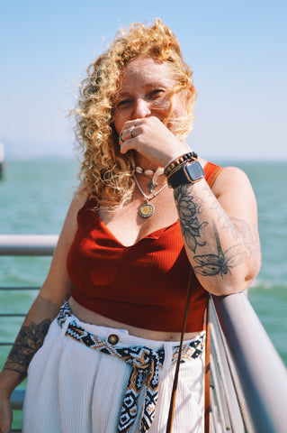 person standing leaning on rail in front of the sea