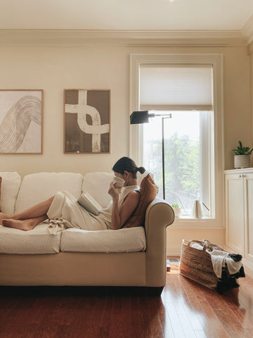 women reading on a sofa with a coffee cup