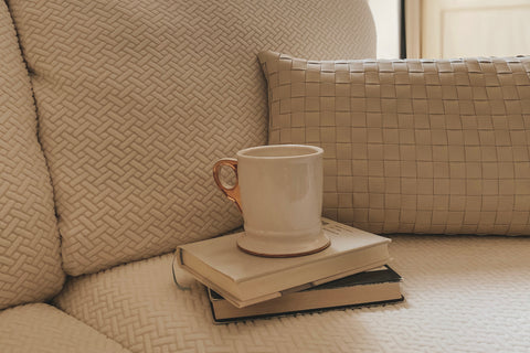 sofa cover with books and a coffee cup