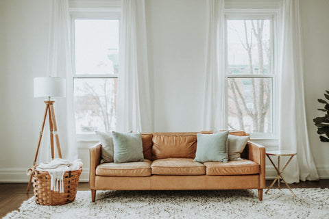tan sofa in front of windows