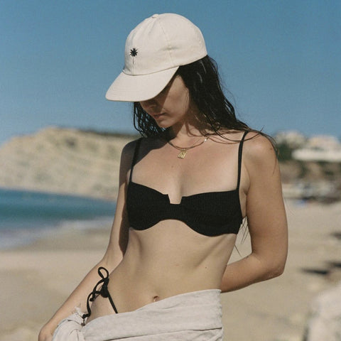 Girl in a black bikini on the beach