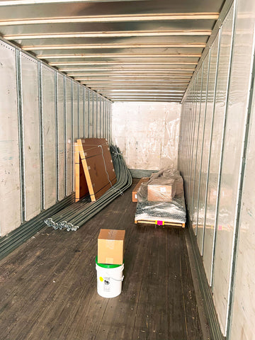 A disassembled Rimol Rolling Thunder greenhouse stacked in the back of a tractor trailer