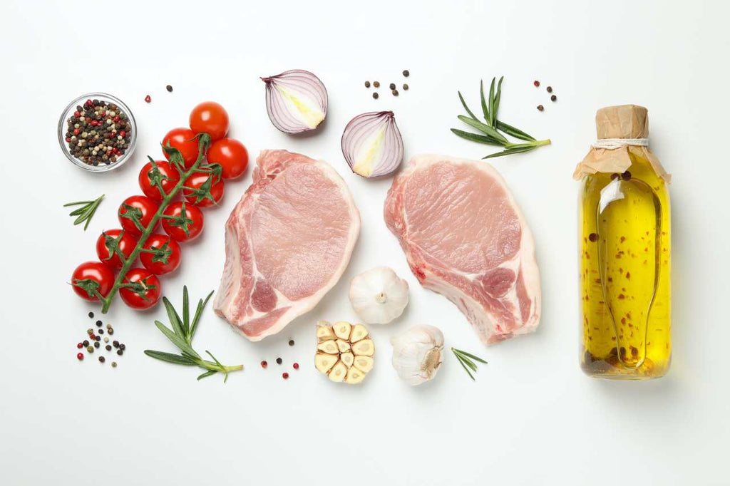 ingredients of beef stew on white background with garlic, onion, peppers, oil