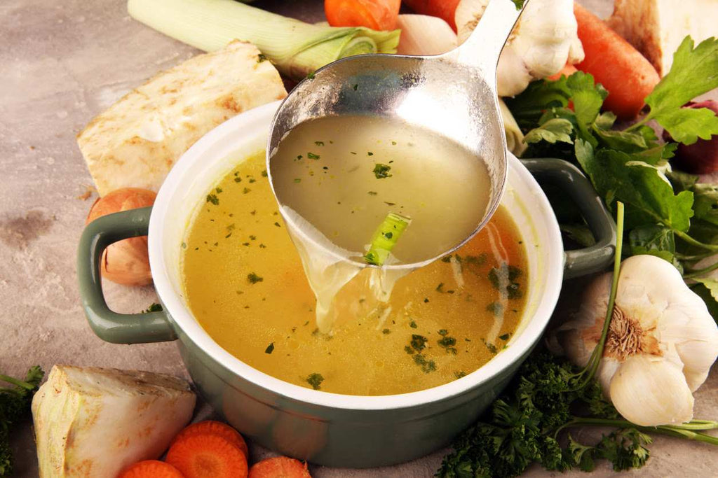 bone broth in a cooking bowl with a ladle
