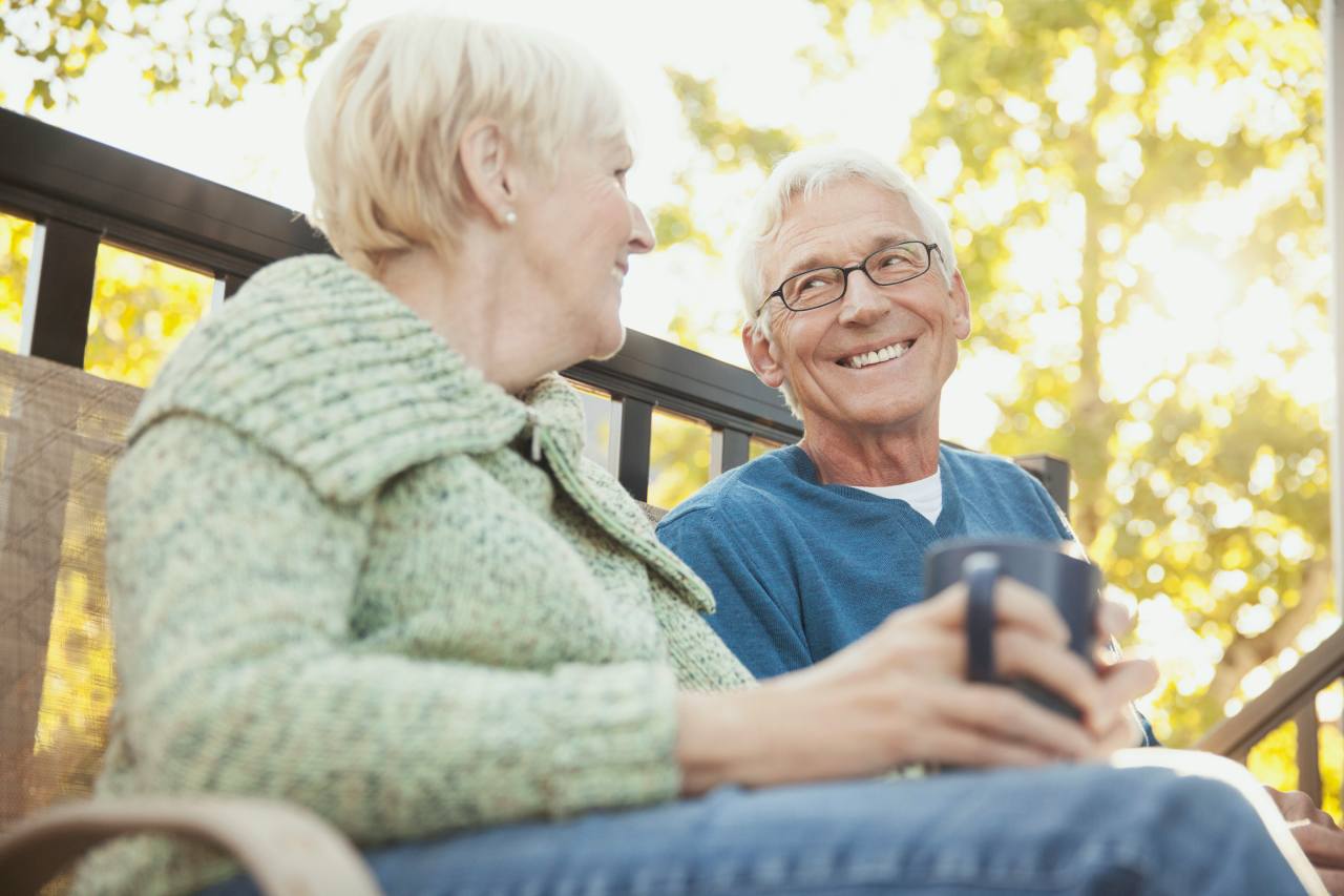 happy elderly couple holding a mug of bone broth outdoor