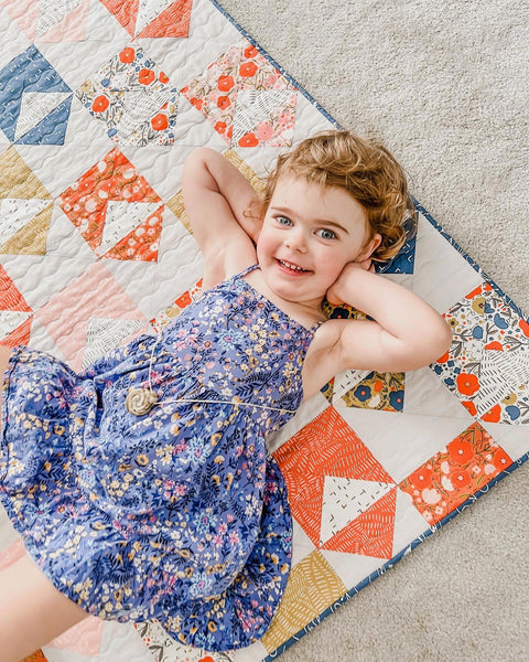 Pippa posing on top of my scrappy Letters quilt