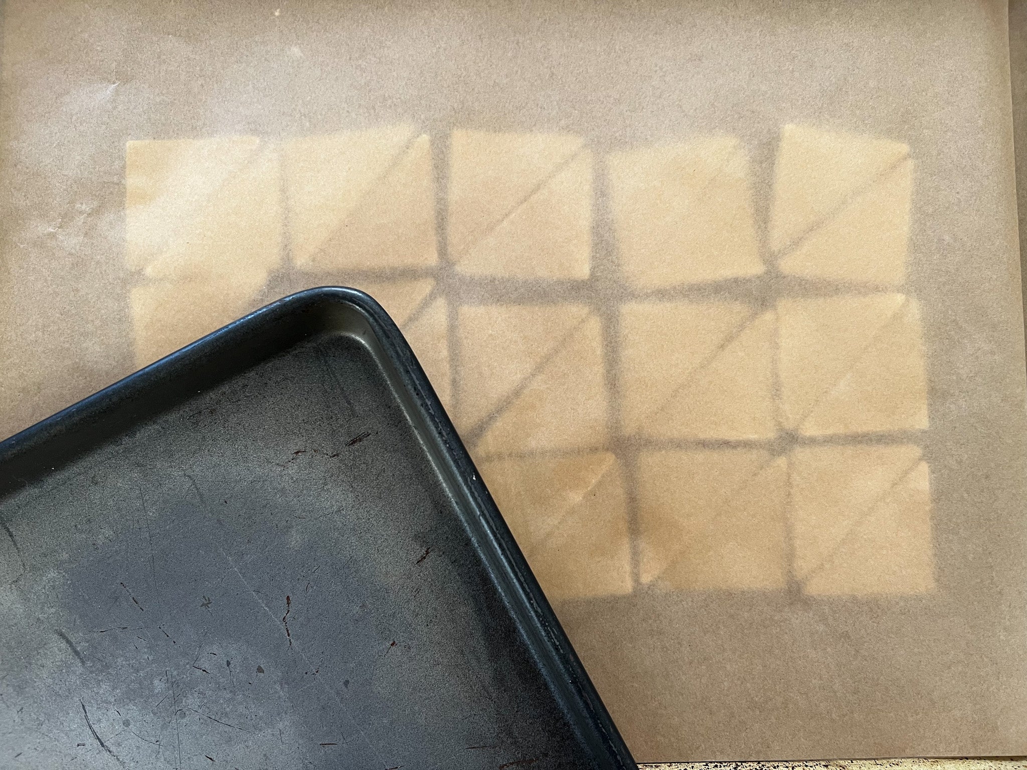 pie crust dough triangles on a pan with parchment paper on top and a second cookie sheet on top to make a quilted pie