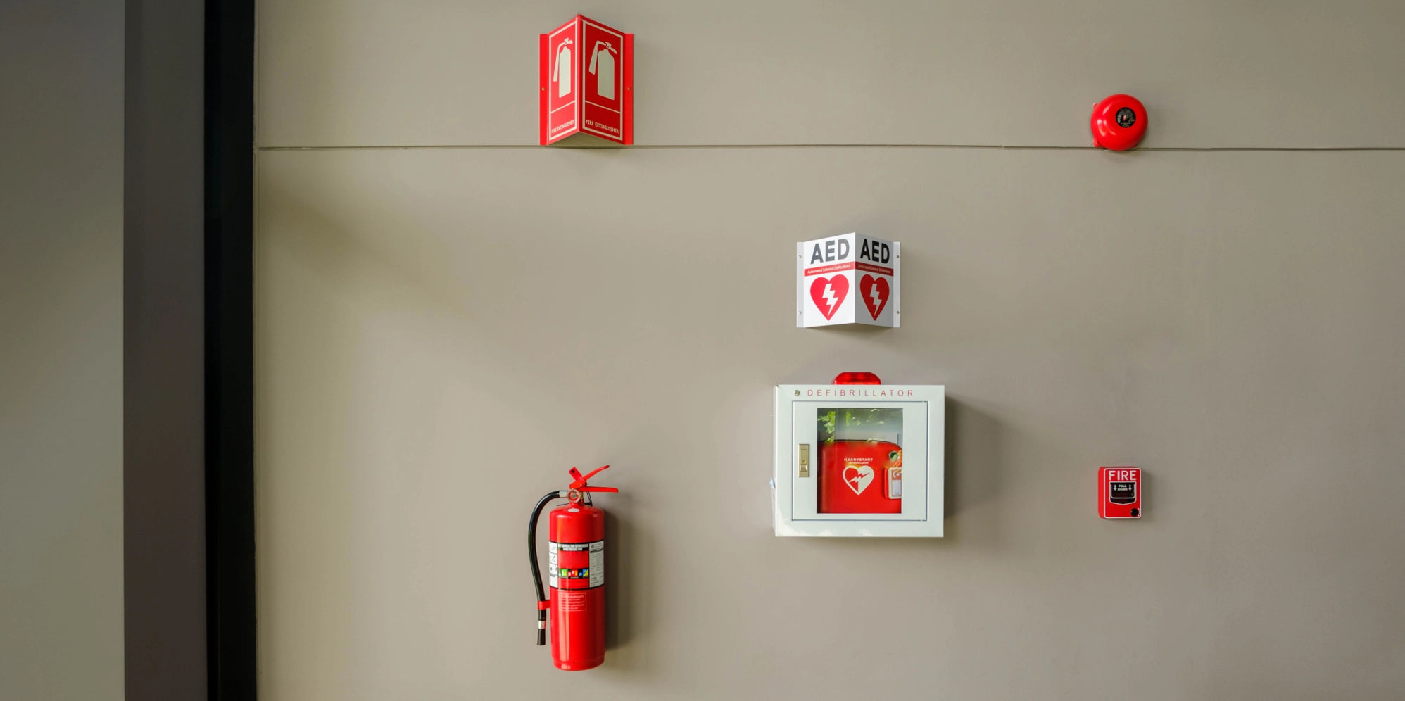 An automated external defibrillator (AED) inside a cabinet against the wall with a fire extinguisher