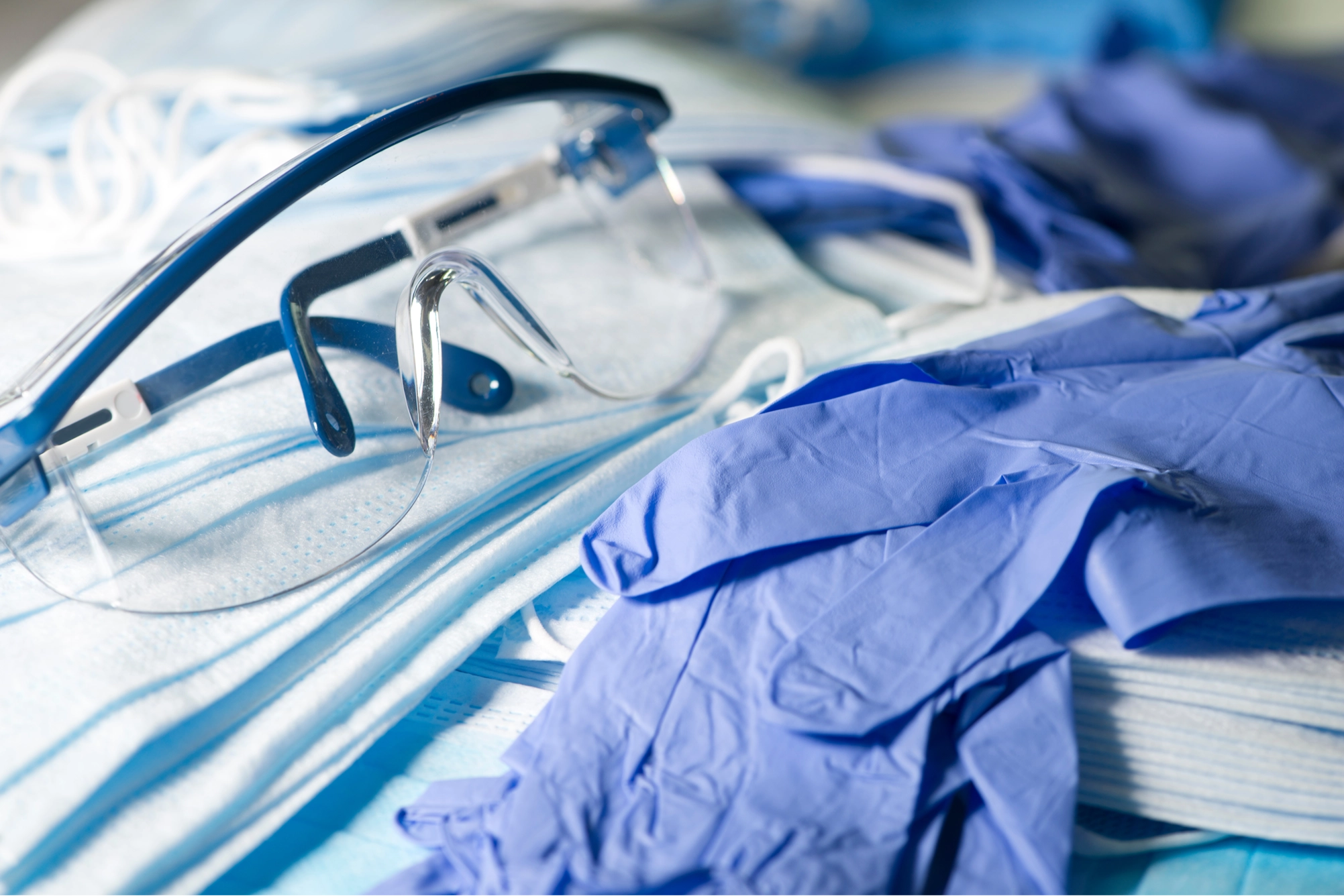 Various personal protective supplies laid out including blue nitrile gloves and disposable face masks.
