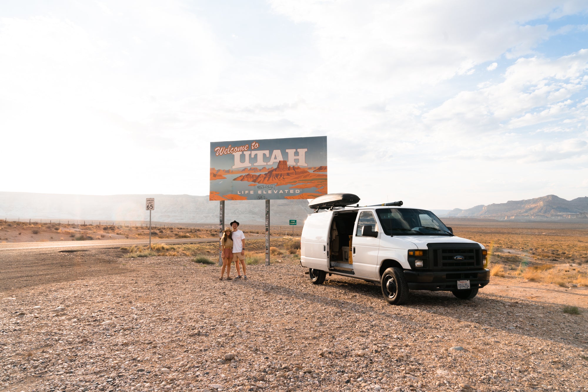 Van in front of "Welcome to Utah" sign