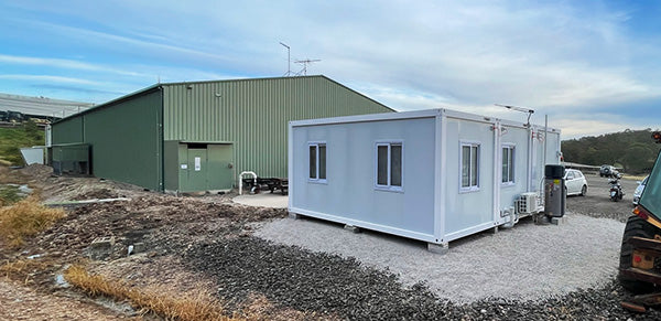 modular container homes in front of barn on farm