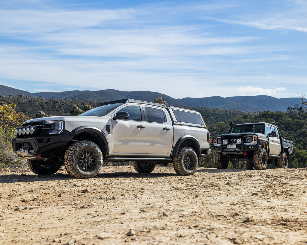 White Ford Ranger and Toyota LandCruiser 79 Series driving off-road with IM2.5 Monotube Shock Absorbers - IRONMAN 4X4