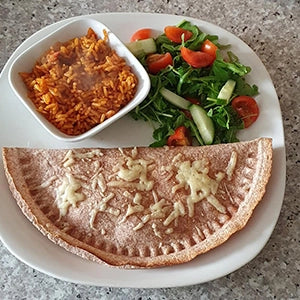 A cooked tortilla with a side of salad and rice 