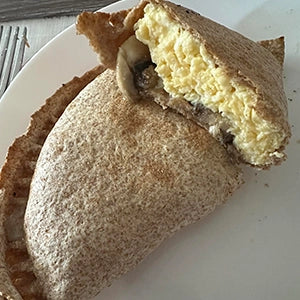 A tortilla filled with egg, cheese and mushrooms