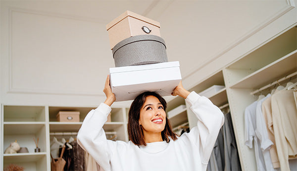 s-blog-frau-balanciert-kartons-auf-dem-kopf-im-schlafzimmer-GettyImages-1451057817.jpg__PID:5c7a9cbd-30c9-4011-a245-972693d1e596