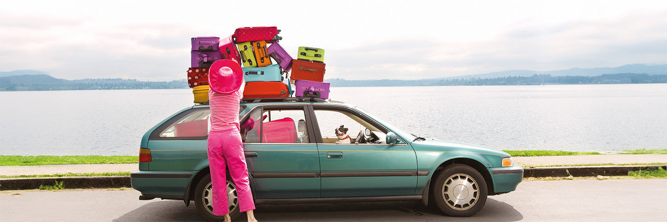 s-h-frau-stapelt-bunte-koffer-auf-auto-vor-einem-see-GettyImages-82827717.jpg__PID:7f50e81e-ddd4-4b05-b1ca-875d17bc06f3