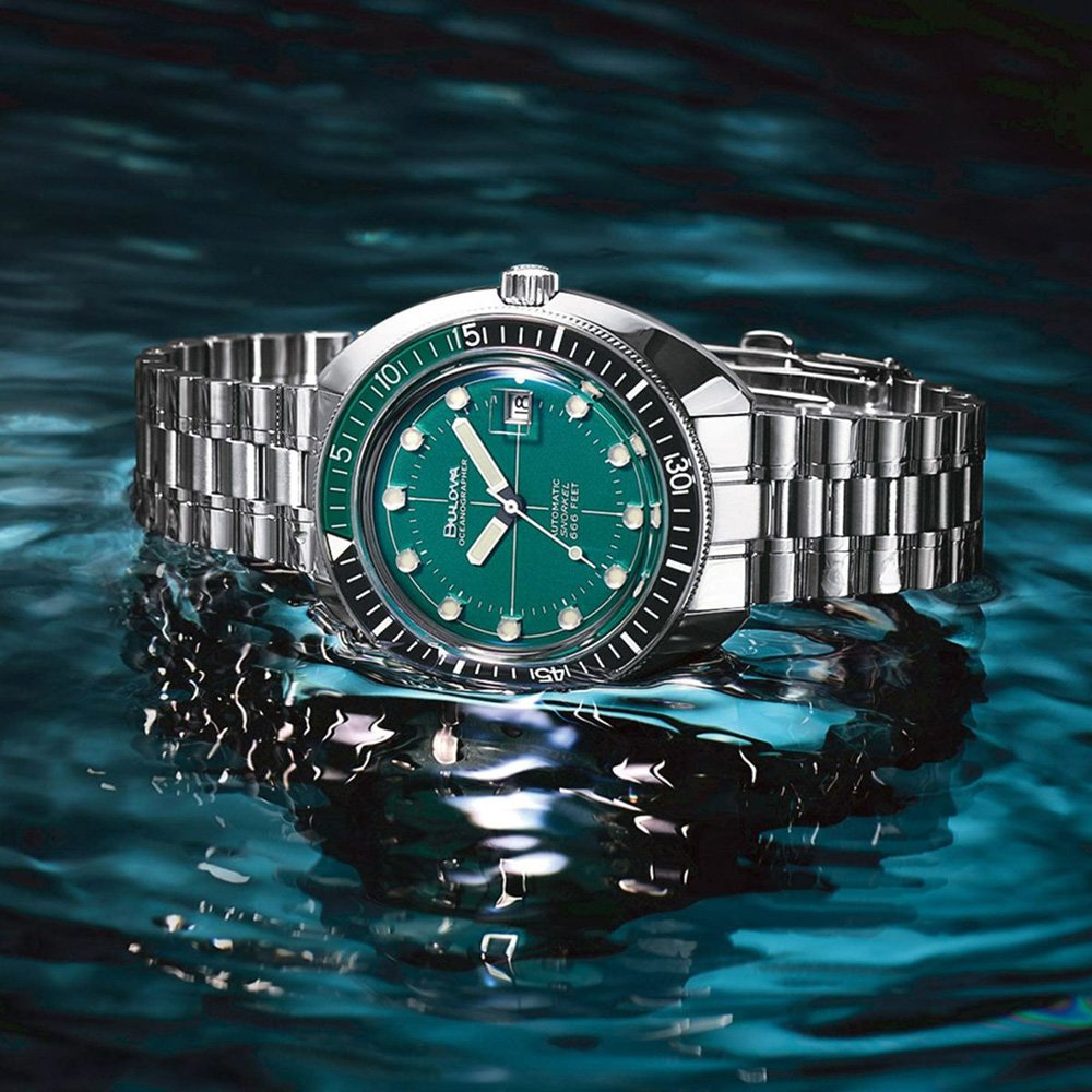 10 Best Dive Watches - Complete Guide For 2022. Green Bulova Oceanographer Devil Diver in water reflection.