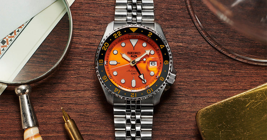 Seiko GMT. Orange SSK005K resting on wooden table. 