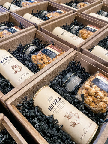 Holiday client gifts for Client Attraction University included Public Goods Cot Cocoa, Cocoa Nib Caramel Popcorn, and 4oz Balsam Fir Candle in a stained wooden gift box.