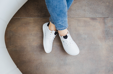 All white sneaker with black decorative color on the heel