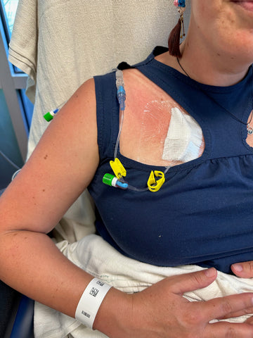 woman in medically accessible adaptive wear top getting a chest port infusion
