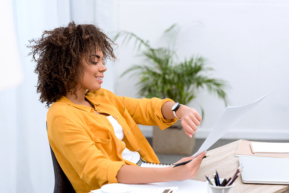Woman checking the time while working on text documents