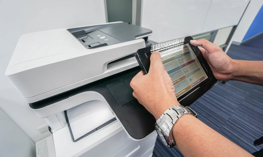 User operating the touchpad of an office copier