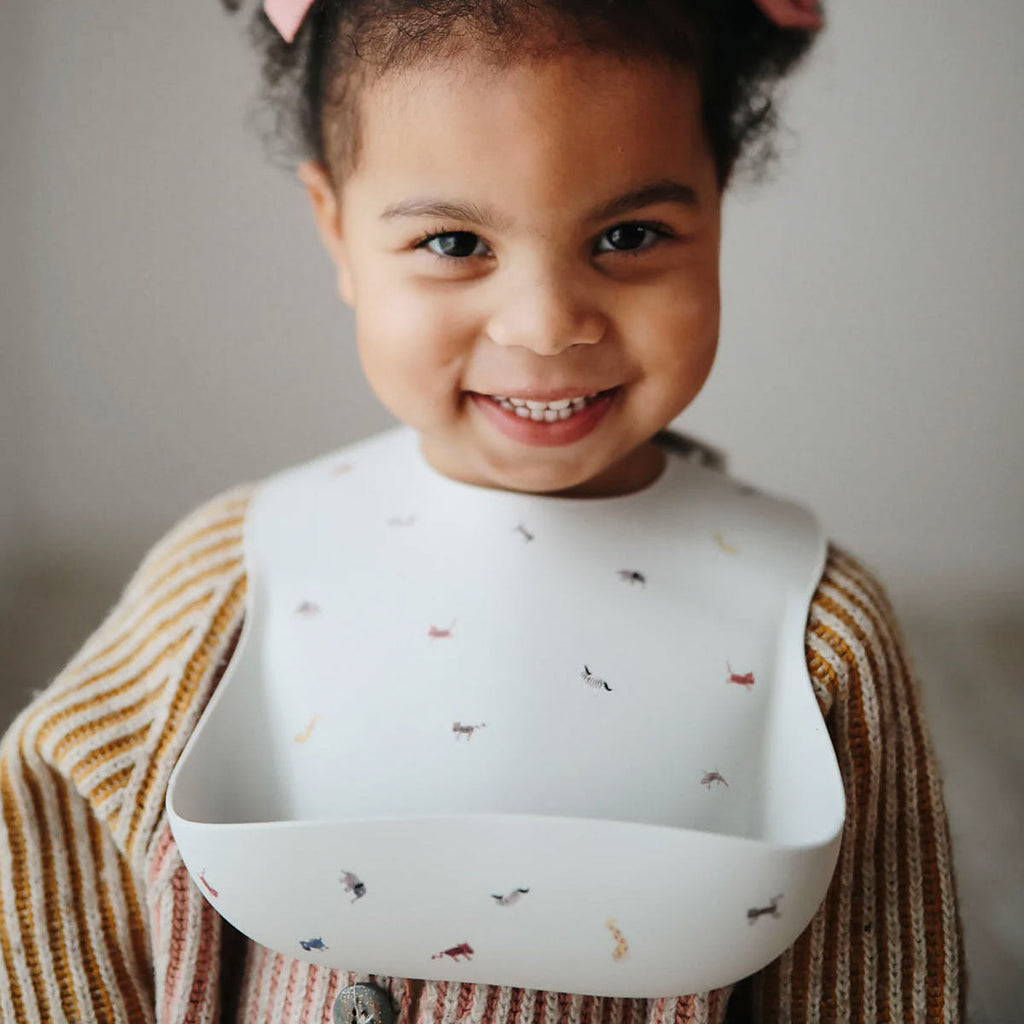 Uśmiechnięta dziewczynka dziecko ze śliniakiem silikonowym