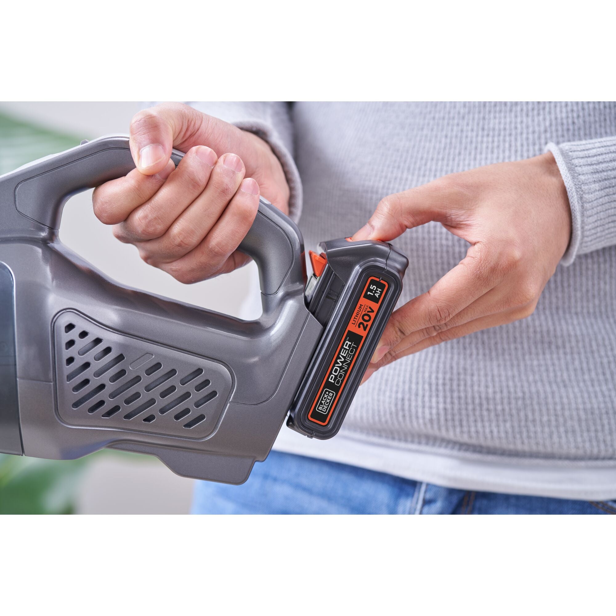 A man is cleaning the kitchen floor using a BLACK+DECKER dustbuster® POWERCONNECT™ 20V MAX* Cordless Handheld Vacuum.