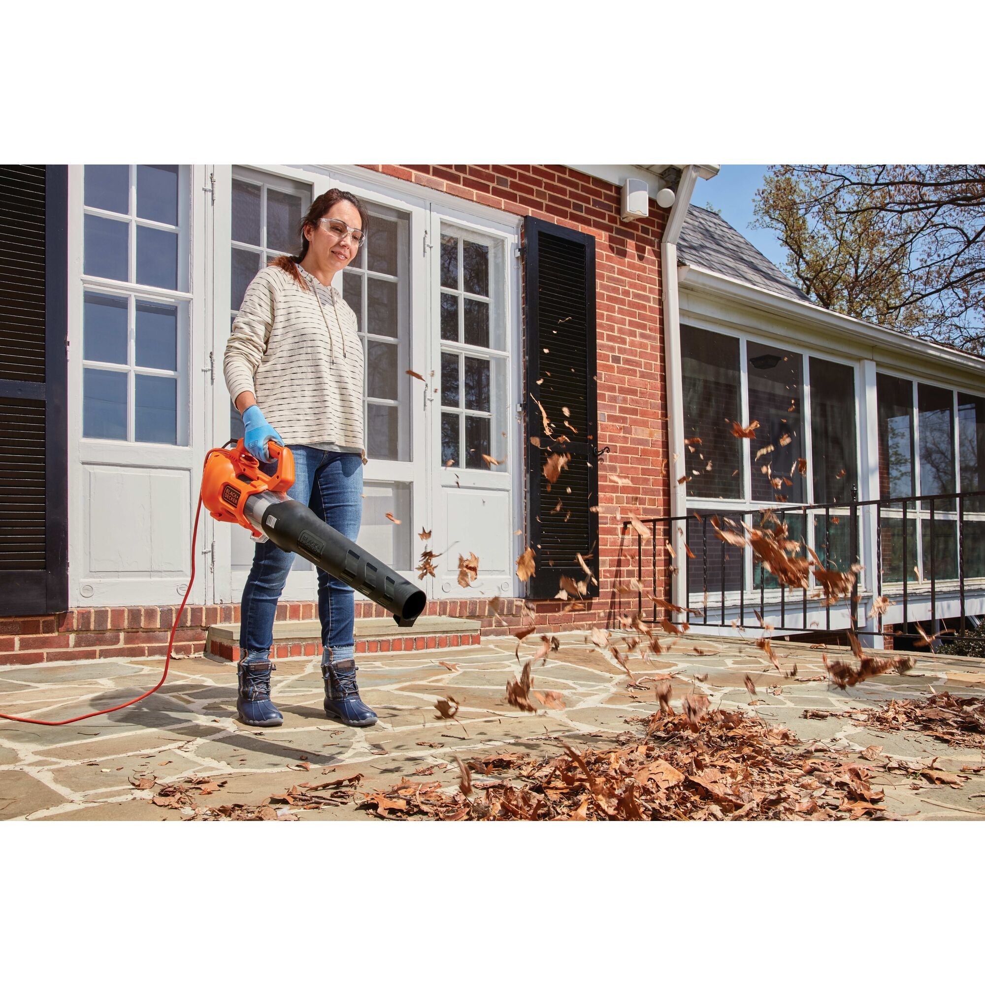 A man clears the yard with the BLACK+DECKER 9-Amp Axial Leaf Blower. Compact and lightweight. Easy to maneuver with less fatigue.