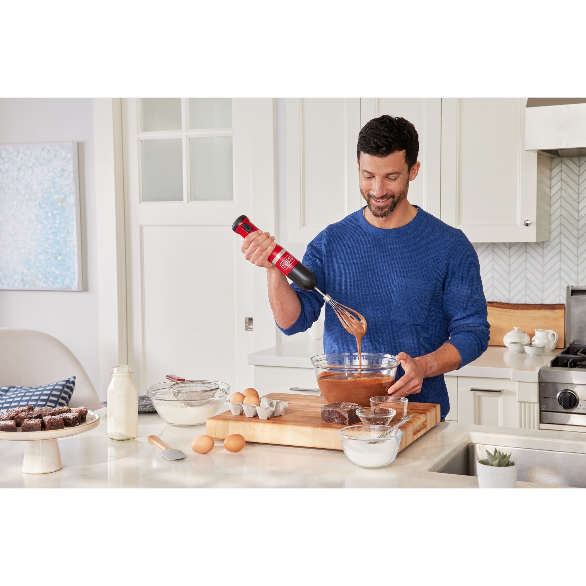 Talent using the red, BLACK+DECKER kitchen wand whisk to prepare brownie batter