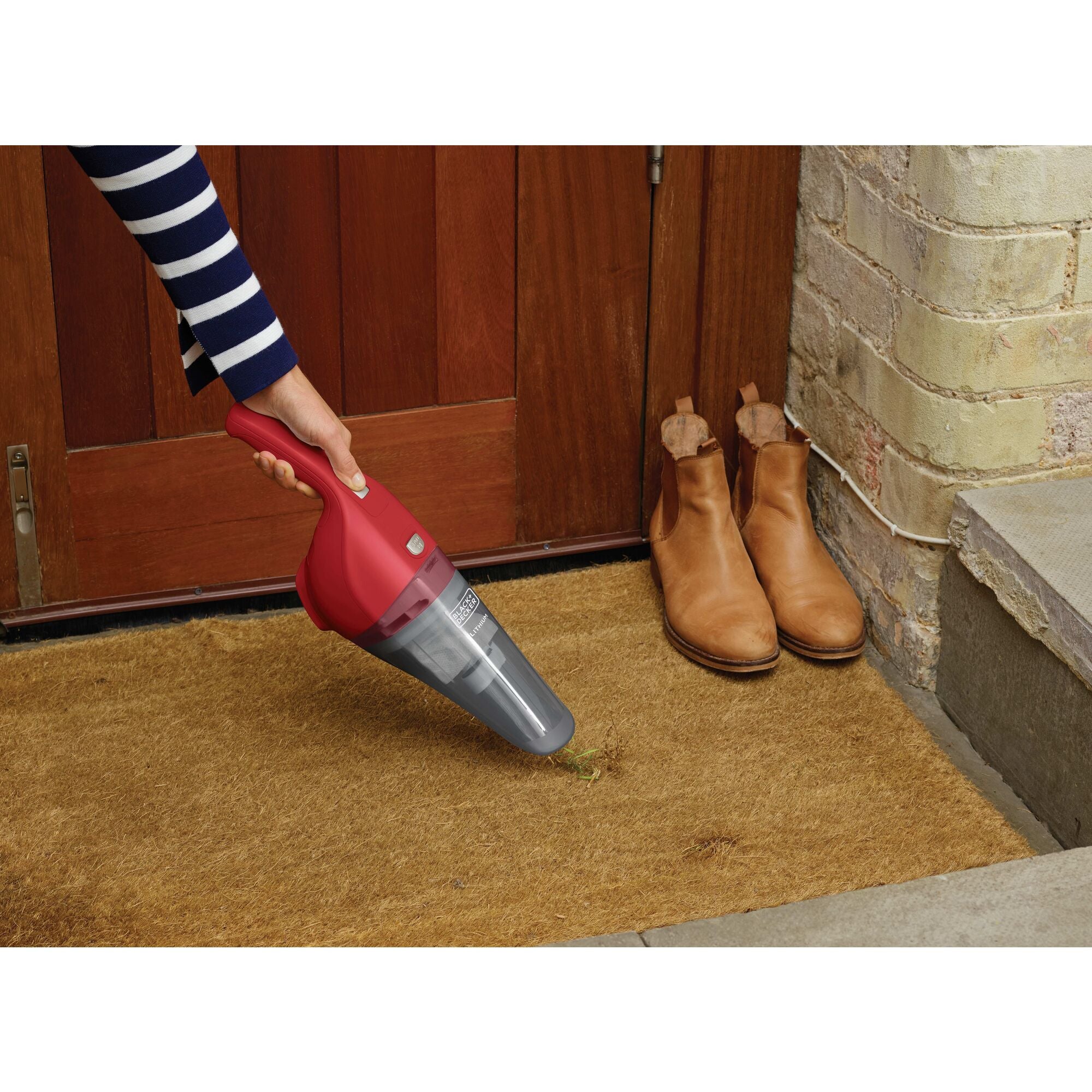 Handheld Vacuum Cordless being used to clean dirt from door mat.