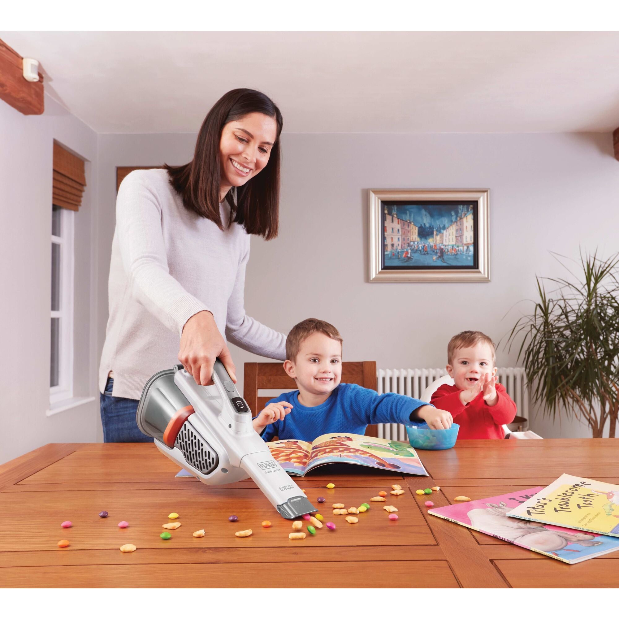 dustbuster Advanced Clean plus Cordless Hand Vacuum being used by person to pick up snacks from table.