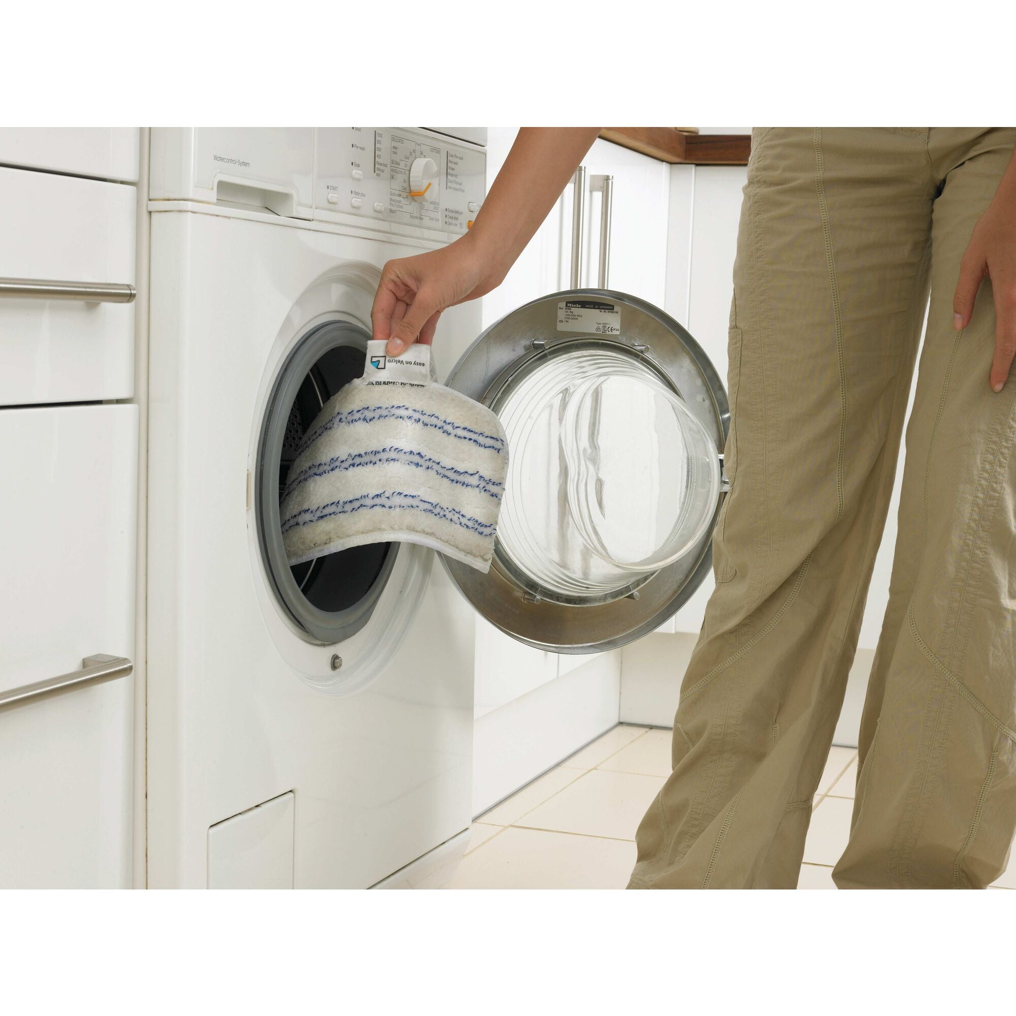 Steam Mop Washable Microfiber Cleaning Pads being washed in a washing machine by a person.